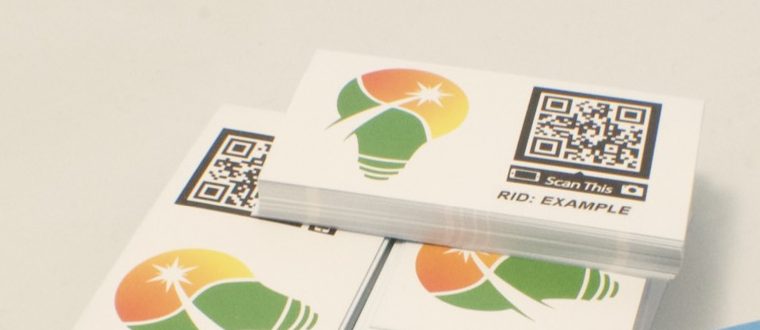 Stacks of printed Solar Strive cards, each showing the bulb mark beside a scannable QR code.